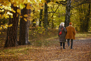 Two people walking down a path in the woods.